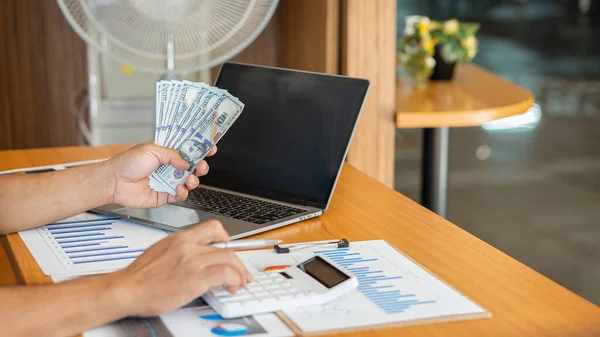 Business people counting money at work Men make money easily Successful business people rejoice at good deals A fun manager throws a lot of money at work on a table with graphs and a laptop.