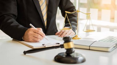 Male attorney advisor or judge advisor concept, having team meetings with clients, legal concepts and hammer attorneys with fair scales on desks in the office.