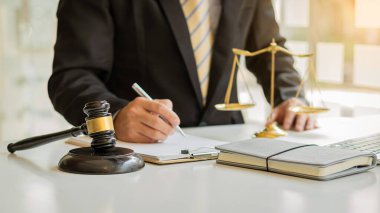 Male attorney advisor or judge advisor concept, having team meetings with clients, legal concepts and hammer attorneys with fair scales on desks in the office.