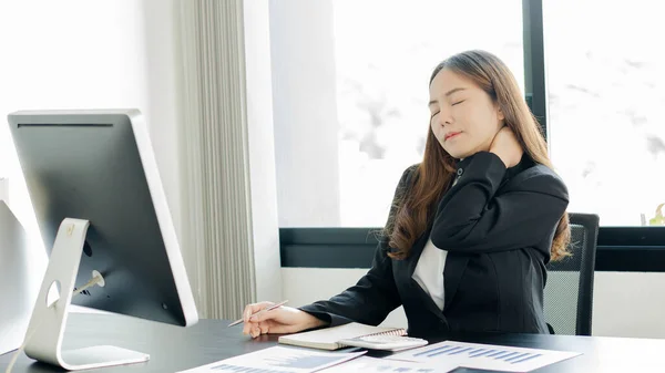 A young business woman suffering from fatigue and pain from work