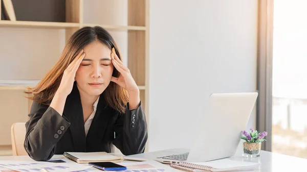 A young business woman suffering from fatigue and pain from work