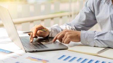 İş adamları el sıkışır, grafikleri analiz eder, ofiste dizüstü bilgisayarlarla çalışır, stratejik planlama ve beyin fırtınası üzerine notlar yazarlar.