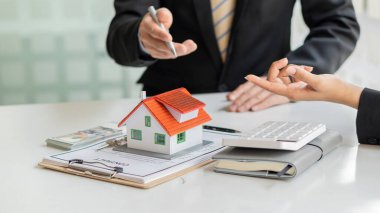 İş adamları ve emlakçılar müşterileri tanıtır ve ev sigortası satın alıp kontrat imzalarlar. Ev sigortası konsepti. Ve bir ev satarak.