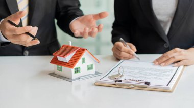 İş adamları ve emlakçılar müşterileri tanıtır ve ev sigortası satın alıp kontrat imzalarlar. Ev sigortası konsepti. Ve bir ev satarak.