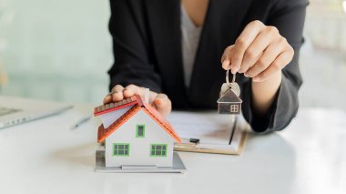 İş adamları ve emlakçılar müşterileri tanıtır ve ev sigortası satın alıp kontrat imzalarlar. Ev sigortası konsepti. Ve bir ev satarak.