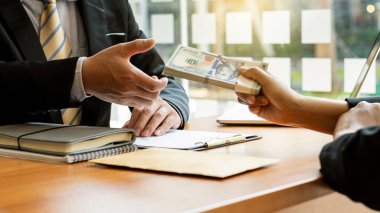  İşadamı dosyada önerilen para ve kahverengi zarfı aldı - ofis rüşveti ve yolsuzluk fikirleri.