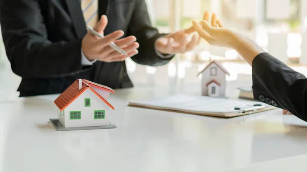 Businessmen and real estate agents introduce clients and negotiate home insurance purchase and sign contracts. Home insurance concept. And selling a home.