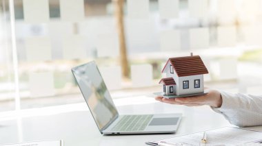 Bir emlakçı müşterilerine gayrimenkul satın almalarını ya da kiralamalarını tavsiye eder..