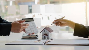 Bir emlakçı müşterilerine gayrimenkul satın almalarını ya da kiralamalarını tavsiye eder..