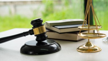 Mahkeme çekiç ve adalet terazisi masanın üzerinde bir defterle..