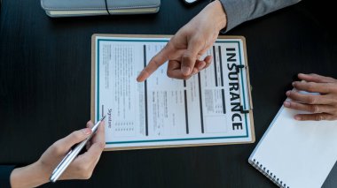 Ofisteki müşteri ve temsilci personel arasında sigorta sözleşmesi imzalama kavramı.