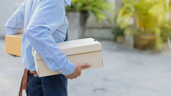 The courier holding the box in hand, the concept of sending and receiving