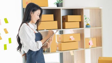 Çekici genç Asyalı girişimciler kameraya mutlu bir şekilde ev kutularında bakıyorlar, paket teslimatını sme tedarik zinciri, satın alma, omnichannel satın alma, çevrimiçi satış konsepti.