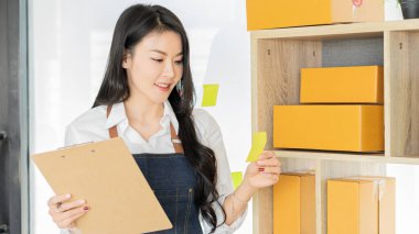 Çekici genç Asyalı girişimciler kameraya mutlu bir şekilde ev kutularında bakıyorlar, paket teslimatını sme tedarik zinciri, satın alma, omnichannel satın alma, çevrimiçi satış konsepti.