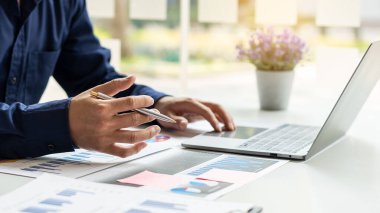 İşadamları şirketin birden fazla olası maliyet grafiklerini analiz eder..