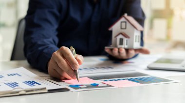 İşadamları şirketin birden fazla olası maliyet grafiklerini analiz eder..