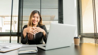 Sevgili genç Asyalı muhasebeci ofiste bilgisayar ve hesap makineleri üzerinde çalışmaktan zevk alıyor..