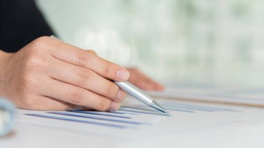 Yatırımcılar mali raporları ve temel performans göstergelerini analiz ederler. Ofisteki iş veri grafiklerini analiz ederek.