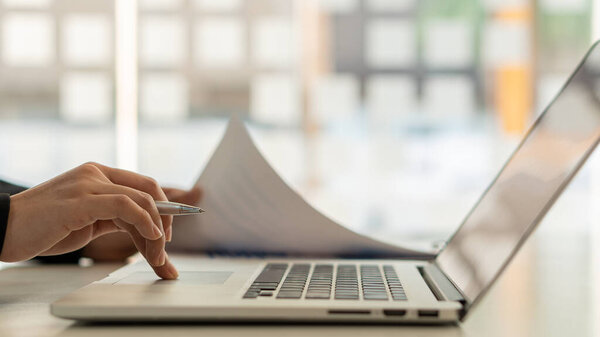 Бизнесмен сидит за столом для анализа графиков. На графиках и графиках с офисными калькуляторами