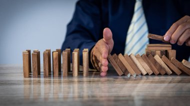İş adamı elleri konsepti durdurdu, domino etkisi risk planlama ve iş stratejisi için sıraya girdi ve tahta kilidi açtı.