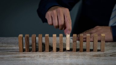 İş adamının eli, işadamlarının iş fikirleri, planlama, risk ve yatırım stratejilerini seçmek için çeşitli tahta bloklardan birini seçiyor..