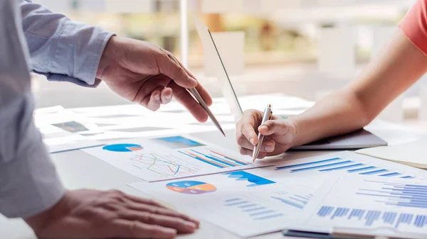 Business people or finance professionals analyze graphs, business reports and financial charts at corporate offices, economic concepts, finance, business, banking.