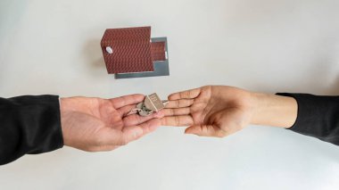 Satılık emlak komisyonculuğu sözleşmeleri ve ofisteki masada bir ev..