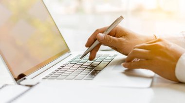 Uzaktan kumandayla çalışan bir iş adamının sosyal ağlarla iletişim kuran ahşap bir masada oturup internetten bilgi ararken yan görüntüsü..