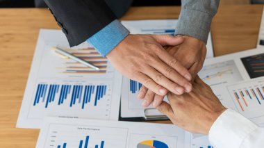 İş adamları, grafik analizinden sonra iş anlaşmaları yapmak için el sıkışırlar..