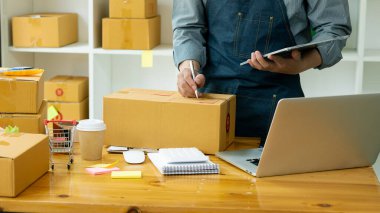 Girişimciler Küçük İşletme Bağımsız Adamlar evde çalışıyor. Ticari denetim, çevrimiçi pazarlama, paketleme, KOBİ satıcıları, konsept, e-ticaret ekibi, çevrimiçi satış için akıllı telefon ve dizüstü bilgisayar kullanın.