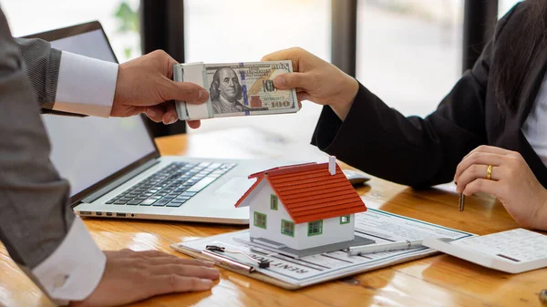 Ein Immobilienmakler Führt Seine Klienten Mit Vertragsunterlagen Und Laptop Und — Stockfoto