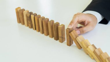 İş Riski İşadamı masadaki tahta bloğu savunuyor, alternatif iş risklerinde planlama ve strateji yapıyor