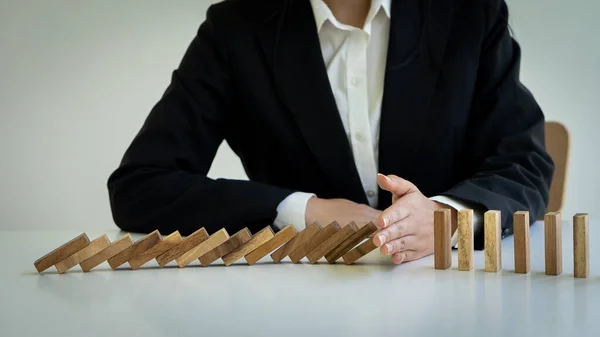 Business Risk Businessman defends the wood block on the table, planning and strategy in alternative business risks