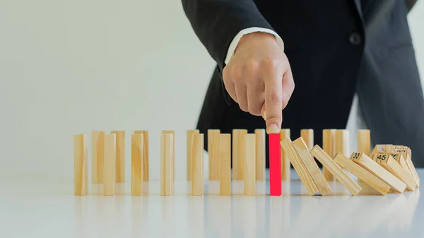 Business Risk Businessman defends the wood block on the table, planning and strategy in alternative business risks