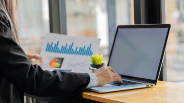 : İşadamı, modern bir dizüstü bilgisayarla gelir tabloları ve grafiklerini analiz ediyor. Ve strateji fikirleri