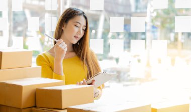 Dizüstü bilgisayarlar ve telefonlar ile çalışan küçük işletme sahipleri, iş yerinde cep telefonu ve karton kutular, küçük işletme girişimcileri, evdeki kutularla çalışan KOBİ, çevrimiçi satış, e-ticaret.