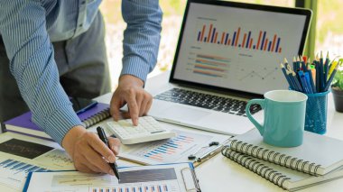 İşadamı şirketin mali belgelerini kullanıyor, veri grafiğini analiz ediyor ve evet. Büyüme hesap makinesi Finansal kavram.