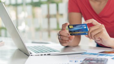 İş kadınları kredi kartı tutuyor ve online, e-ticaret, internet bankacılığı, para harcamak, evden çalışmak için dizüstü bilgisayar ve cep telefonu kullanıyorlar..