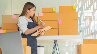 Dizüstü bilgisayarlar ve telefonlar ile çalışan küçük işletme sahipleri, iş yerinde cep telefonu ve karton kutular, küçük işletme girişimcileri, evdeki kutularla çalışan KOBİ, çevrimiçi satış, e-ticaret.