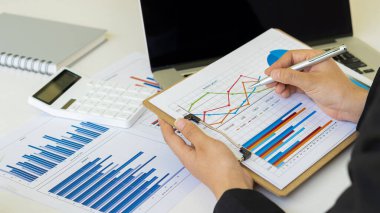 Yatırım maliyetleri, gayrimenkul ve daha fazlasının grafiklerini çıkarmak, hesaplamak, hesaplamak, hesaplamak, hesaplamak ve finanse etmek gibi işler yapan iş adamları, dizüstü bilgisayarlarla ve belgeli hesap makineleriyle masanın üzerinde duran vergi sistemi.