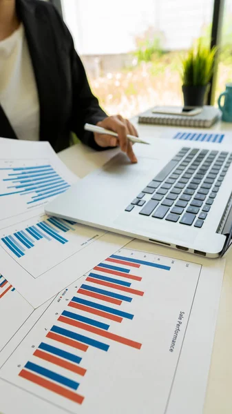 Business people doing business in finance and calculating, analyzing, graphing on costs of investments, real estate and more, tax system on the desk with laptops and calculators with documents