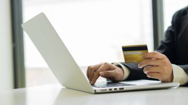 Genç kadınlar kredi kartı tutuyor ve online alışveriş yapmak için dizüstü bilgisayar kullanıyorlar, e-ticaret, internet bankacılığı, para harcamak, evden iş.