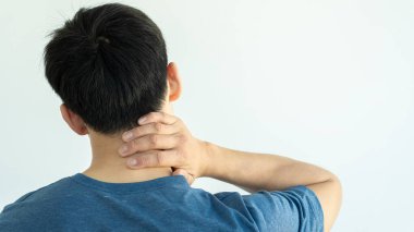 Boynunda ağrı olan ve sağ elini tutan genç bir adam..