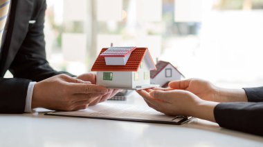 Emlakçılar ofiste evrak işleriyle uğraşırlar. Ve müşterilere satın almaları ve almaları için bir ev planı sunacağız.