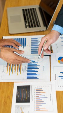 İş grupları toplantıları hesap makineleri ve tabletli laptoplarla grafik analizi hakkında konuşur..