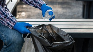 Adam plastik şişeleri topluyor, dünyadaki çöpleri topluyor, parktaki ormanı temizliyor. Bağış ortamını korumak için