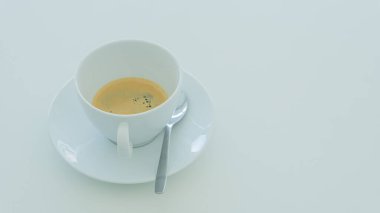 İçme masasında uyuşukluk için beyaz kahve fincanları var..