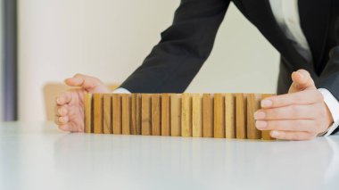İşadamı ahşap blok ve iş risk stratejisini koruyor. Seçim ve inşaat işi, iş risk kontrol kavramının önlenmesi..