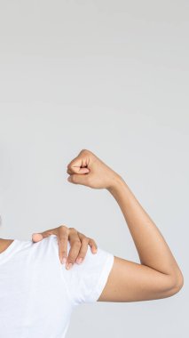 Ağır omuz ağrısı olan ve ellerini beyaz arka plan tıbbi konseptiyle kaplayan bir kadın..