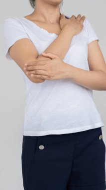 Dirsek ağrısı olan bir kadın. Kolu ve eli beyaz arka plan tıbbi konseptiyle kaplı.